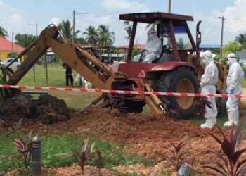 MOHD. Muzzamil Yaakob mengendalikan jengkaut bagi kerja mengorek kubur untuk mengebumikan pesakit Covid-19 yang meninggal dunia di sebuah tanah perkuburan Islam di Alor Setar, Kedah. – UTUSAN/MOHD. RIFAAT ABD. HAMID