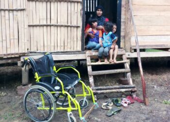 AKILAH Yahaya bersama tiga orang anak di rumahnya yang berdinding dan berlantaikan buluh di Kampung Padang, Rambong Batu 7, Jalan Kroh, Baling hari ini.