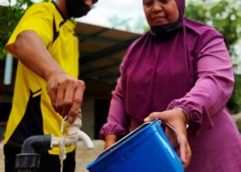 NORIZA Mahmud (kanan) dan suami, Abdul Wahid Hasan menunjukkan paip SADA yang tidak mengeluarkan air di rumahnya di Kampung Padang Toi, Sik. - UTUSAN/NORLIA RAMLI