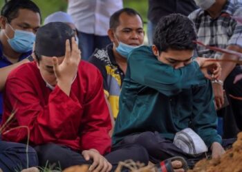 ANAK mangsa, Farid Ridhwan Mohd. Irfan Fikri (kiri) bersama Farhan Hasif tidak dapat menahan sebak selepas jenazah bapanya, Allahyarham Mohd. Irfan Fikri Mohd. Rawi selamat dikebumikan di Tanah Perkuburan Islam USJ 22 di sini hari ini. -UTUSAN/FARIZ RUSADIO