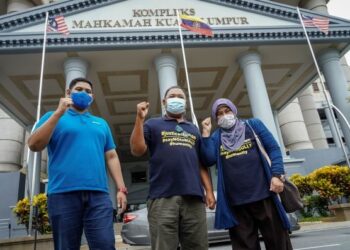 ZULKARNAIN Idris (tengah) bersama isteri, Hawa Osman dan anak, Zulhelmie Idros ketika penghakiman enam penuntut Universiti Pertahanan Nasional Malaysia (UPNM) di Kuala Lumpur. - UTUSAN/FARIZ RUSADIO