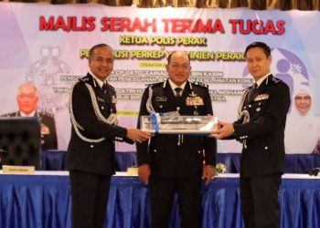 RAZARUDIN Husain (kiri) menyerahkan tongkat kuasa kepada Goh Boon Keng (kanan) yang akan memangku jawatan Ketua Polis Perak dengan disaksikan Pengarah JPJKK Bukit Aman, Datuk Zainal Abidin Kasim (tengah) di Mes Pegawai Kanan PDRM Perak di Ipoh, Perak hari ini. - FOTO/ASLIZA MUSA