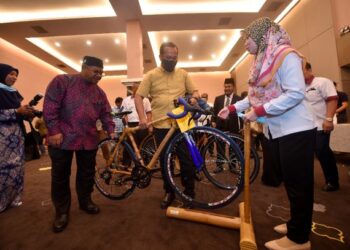 KHAIRUDDIN Aman Razali (dua dari kiri) melihat Ahmad Samsuri memegang basikal yang diubahsuai menggunakan buluh pada Program Seminar Aplikasi Buluh dalam Industri Pembinaan di Hotel Paya Bunga (PB), Kuala Terengganu hari ini. - FOTO/ROSALINDA MD. SAID