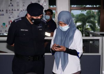 MIOR  Faridalathrash Wahid memeriksa aplikasi MySejahtera seorang pekerja kilang dalam Operasi Bersepadu Pemantauan Covid-19 di Taiping, Perak,  hari ini. - UTUSAN/ZULFACHRI ZULKIFLI