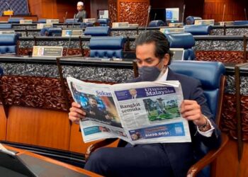 KHAIRY Jamaluddin membaca akhbar Utusan Malaysia di Parlimen, Isnin lalu.