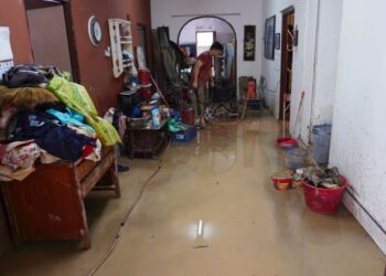 PENDUDUK membersihkan rumah kediaman mereka akibat banjir di Kampung Lembah Jaya Ampang di sini hari ini. -UTUSAN/FAUZI BAHARUDIN