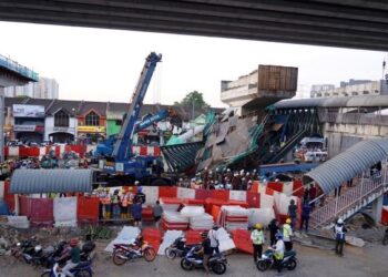 KEJADIAN bahan binaan jejambat yang jatuh dan kerja-kerja mengalihkan bahan binaan di Jalan Lingkaran Tengah 2. - UTUSAN/FARIZ RUSADIO