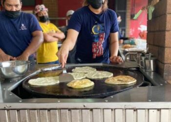 MOHD. Faizul Rohban Ahmad (kanan) menyiapkan roti canai untuk pelanggan di kedainya di Pasir Pekan, Tumpat baru-baru ini. - UTUSAN/ROSLIZA MOHAMED