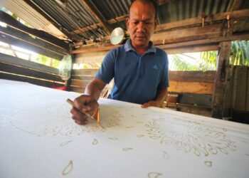 ROSLI Yaakob tekun mencanting batik di kilang miliknya di Kampung Semut Api, Kota Bharu.-UTUSAN/ ZULHANIFA SIDEK