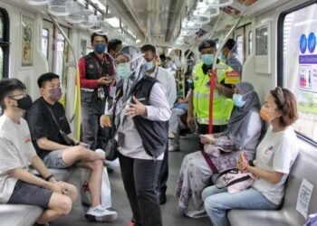 DR. NORIAH Hajib memberi penerangan kepada penumpang mengenai pentingnya mematuhi SOP dan penjarakan sosial bagi memerangi pandemik Covid-19 dalam program pematuhan SOP di dalam tren oleh Kementerian Kesihatan di LRT Laluan Ampang/Sri Petaling semalam. - FOTO/MOHD. FAITH EZENE 