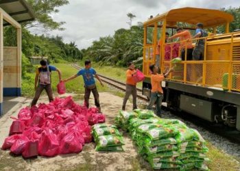 PETUGAS KTMB bekerja keras memindahkan barangan bantuan untuk dihantar kepada mangsa banjir di Pahang. - FB KTMB