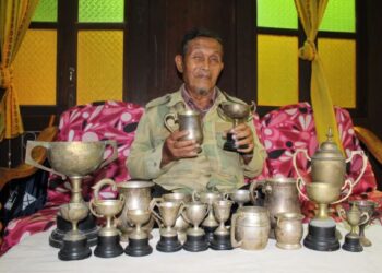 KAMARUDDIN Itam bersama lebih 50 pingat yang diperolehnya sepanjang 22 tahun bertugas dalam tentera. – FOTO/NOR AINNA HAMZAH