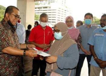 MOHAMED Khaled Nordin menyampaikan bantuan kepada penerima dalam Program Bantuan Makanan Yayasan Pasir Gudang di Pasir Gudang, Johor, semalam. - FOTO/BAAZLAN IBRAHIM