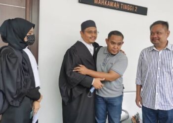 MOHAMAD Maliki Abdul Hakim (dua dari kanan) berpelukan dengan peguam yang mewakilinya, Shaharuddin selepas menang kes saman di Mahkamah Tinggi, Kota Bharu, Kelantan. - FOTO/ROSALWANI CHE SOH