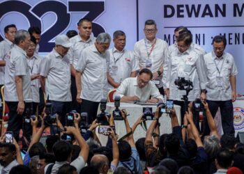 Anwar Ibrahim menandatangani Tekad Bersama Kerajaan Perpaduan disaksikan pemimpin-pemimpin parti pada Konvensyen Nasional Kerajaan Perpaduan 2023 di Dewan Merdeka WTC, Kuala Lumpur, semalam. - UTUSAN/FARIZ RUSADIO