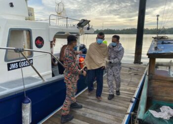 MOHD. Norizan Jusoh (tengah) dibawa ke darat selepas bot dinaiki dia dan rakannya karam pada malam kelmarin di perairan Tanjung Sedili, Kota Tinggi, Johor.