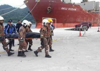 ANGGOTA bomba mengangkat mayat pemandu lori yang lemas selepas mangsa bersama lori yang dipandunya terjunam dalam laut di Lumut Port di Sitiawan hari ini. - UTUSAN