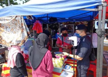 PEGAWAI Penyelia OP Covid IPD Manjung, Asisten Superintendan Heng Kok How (kanan) melakukan pemeriksaan ketika operasi di sekitar Pulau Pangkor, Perak, semalam. - IHSAN PDRM