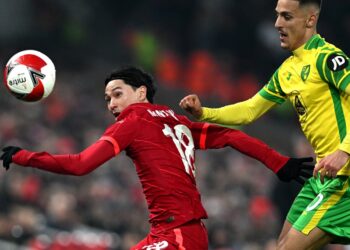 PERTAHANAN Norwich City, Dimitris Giannoulis (kanan) bersaing dengan penyerang Liverpool, Takumi Minamino dalam perlawanan pusingan kelima Piala FA di Anfield, Liverpool hari ini. - AFP