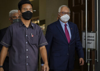 NAJIB Tun Razak (kanan) berjalan keluar selepas hadir perbicaraan kes dihadapinya berhubung dana 1Malaysia Development Berhad (1MDB) di Kompleks Mahkamah Kuala Lumpur di sini, hari ini. -UTUSAN/ FARIZ RUSADIO