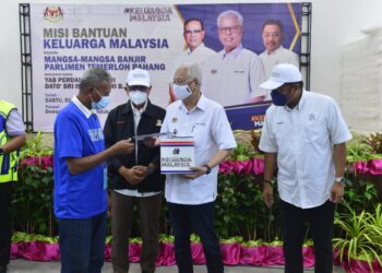 ISMAIL SABRI Yaakob (dua dari kanan) bertanyakan sesuatu kepada penerima bantuan sumbangan banjir di Dewan Majlis Perbandaran Temerloh Dataran Bahaman di Lanchang, Temerloh, Pahang. - UTUSAN/SHAIKH AHMAD RAZIF