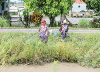 DUA warga emas meluangkan masa lapang dengan memancing di tepi saliran air berdekatan rumah mereka di Jejawi, Arau, Perlis. - UTUSAN/ SHAHIR NOORDIN