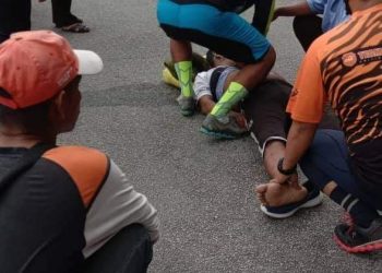 AZERIL SAHAHARUDDIN (terbaring) tidak sedarkan diri setelah terjatuh dari basikal di jalan besar berdekatan Jambatan Kampung Baru Kuala Dipang di Kampar semalam. - MEDIA SOSIAL