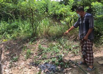 SEORANG penduduk menunjukkan kawasan Mokhtar Mat Nor ditemukan mati akibat renjatan pagar elektrik di rumahnya di Kampung Star Baru, Gua Musang, Kelantan. - UTUSAN/AIMUNI TUAN LAH