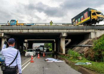 MANGSA tercampak keluar daripada lori dan terjatuh ke atas jalan raya dalamkemalangan di Kilometer 280.7 Lebuh Raya Utara Selatan menghala Selatan, dekat Nilai, Negeri Sembilan petang tadi.- UTUSAN/MUHAMMAD IZZAT TERMIZIE