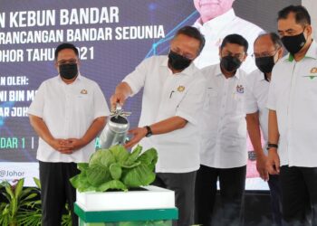 HASNI Mohammad (dua dari kiri) menjirus sayur kobis sebagai simbolik Sambutan Hari Perancangan Bandar Sedunia Peringkat Negeri Johor 2021 dan Pelancaran Kebun Bandar di Taman Impian Emas, Johor Bahru, Johor. - UTUSAN/RAJA JAAFAR ALI