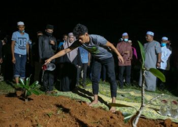 MUHAMMAD Syafiq Ahmad menyiram air di atas pusara anaknya Muhammad Aisy Saqeef, 22 hari untuk dikebumikan dalam satu liang lahad bersama jenazah ibu mentuanya di Tanah Perkuburan Islam Bukit Murai, Kampung Padang Pusing, Pendang semalam.