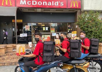 Penghantar McDelivery Service menerima set Quater Pounder dengan keju sumbangan McDonald's Malaysia. - GAMBAR/MCDONALD'S MALAYSIA