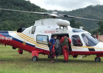 WANITA Orang Asli sarat mengandung yang terperangkap di Pos Gob diterbangkan helikopter Unit Udara JBPM ke Hospital Gua Musang hari ini. - UTUSAN/AIMUNI TUAN LAH