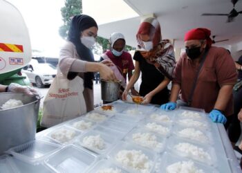 Ahli GSPJ menyiapkan makanan untuk diagihkan kepada mangsa banjir