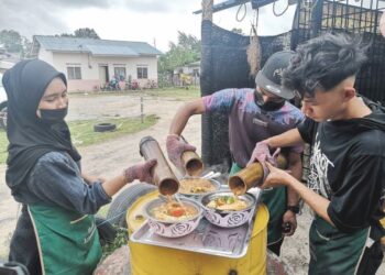 BEBERAPA pekerja mencurahkan kuah mi segera yang dimasak menggunakan buluh ke dalam mangkuk di premis Megi Dapur Arang Jijo di Tok Jembal di Kuala Nerus, Terengganu.