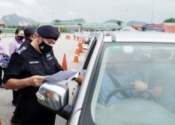 MIOR Faridalathrash Wahid memeriksa surat kebenaran rentas negeri pengguna jalan raya ketika meninjau sekatan jalan raya di Plaza Tol Ipoh Selatan, Ipoh, Perak hari ini. - FOTO/ZULFACHRI ZULKIFLI