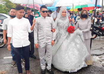 PASANGAN pengantin Mohd. Zulhusaini Hassan dan Nuramira Abdullah mengadakan majlis perkahwinan dua hari selepas PKPP berkuatkuasa di Melaka. -UTUSAN/AMRAN MULUP