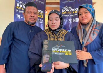 NUR' Inani Husna Ahmad Nahar (tengah) bersama ibu bapanya menunjukkan gambar Muhammad Nafisselepas Majlis Konvokesyen Kolej Komuniti Melaka, semalam. - UTUSAN/DIYANATUL ATIQAH ZAKARYA