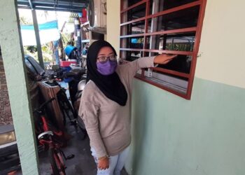 NURULASNIDA Azhar menunjukkan tingkap cermin biliknya yang diganggu ketukan misteri sebanyak dua kali di Lorong Haji Mohd. Noor, Kampung Balik Bukit, Tanjung Kling, Melaka. - FOTO/AMRAN MULUP