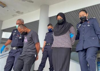 KEDUA-DUA tertuduh diiring keluar anggota polis selepas mengaku bersalah mengabai dan memukul anak sendiri di Mahkamah Sesyen, Ayer Keroh, Melaka. - FOTO/DIYANATUL ATIQAH ZAKARYA