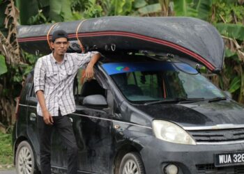 AZWAN Omar bersama kereta Perodua Viva dan bot getah yang digunakan untuk menolong mangsa banjir di Puchong, Shah Alam dan Temerloh. - FOTO/RASUL AZLI SAMAD