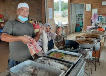 SAMBRI Bodot (kiri) dan Norita Abdullah menunjukkan kepala ikan mayong, ikan senangin dan belangkas di restoran Norita Asam Pedas di Jeti Nelayan Pantai Siring, Serkam, Melaka. - UTUSAN/AMRAN MULUP