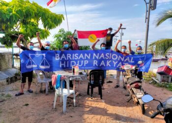 SEBAHAGIAN daripada Komuniti Kesatuan Nelayan Tanjong Kling mengibarkan bendera Barisan Nasional (BN) dan UMNO di Jeti Kampung Hailam, Melaka, semalam. – UTUSAN/AMRAN MULUP