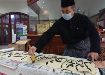 YUSUF Liu Baojun menunjukkan demostrasi tulisan khat kepada umum pada Majlis Intelek Seni dan Anugerah Buku Negara 2022 di Ayer Keroh, Melaka. - UTUSAN MUHAMMAD/SHAHIZAM TAZALI