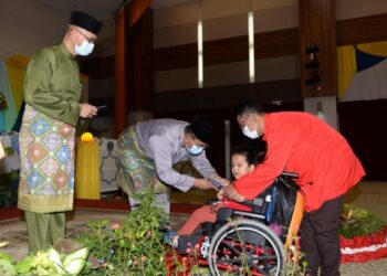 MOHAMMAD Sanusi Md. Nor menyampaikan sumbangan kepada salah seorang kanak-kanak istimewa pada majlis berbuka puasa bersama warga PDRM Kontinjen IPK Kedah di Alor Setar, malam semalam. - FOTO/MOHD. RAFIE AZIMI