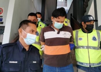 MOHD. Amin Mohamad diiringi anggota polis ketika dihadapkan di Kompleks Mahkamah Ayer Keroh, Melaka. - FOTO/DIYANATUL ATIQAH ZAKARYA