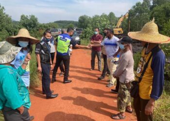 PEGAWAI MPM (kiri) mengarahkan kerja pembersihan yang dilakukan kontraktor atas tanah milik PPPNP Jumaat lalu dihentikan serta-merta kerana tidak mempunyai kelulusan merancang di Sungai Segari dekat Beruas kelmarin.