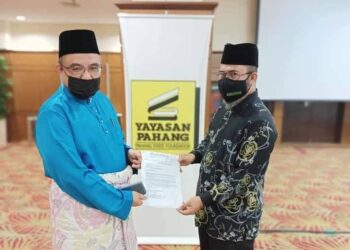 DR. ASMADI Abdul Rahman (kanan) menyerahkan agihan peruntukan kepada Abd. Razak Abd. Musa Syaari (kiri) melalui surat kelulusan dan baucer pembayaran di Kompleks Yayasan Pahang di Kuantan, Pahang. - UTUSAN/ DIANA SURYA ABD WAHAB.