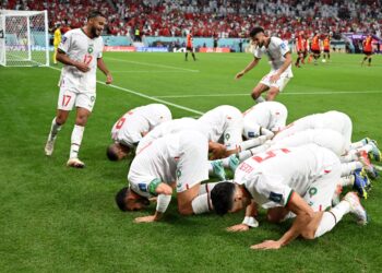 PEMAIN-pemain Maghribi sujud syukur di tepi padang selepas pemain tengah, Abdelhamid Sabiri menjaringkan gol pertama pasukannya menentang Belgium di Stadium Al-Thumama, Doha, kelmarin. – AFP