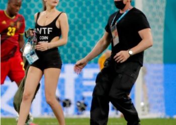 SEORANG pegawal keselamatan mengiringi Maria Shumilina selepas gadis cantik dari Rusia ini menceroboh masuk ke padang ketika Belgium menentang Finland di Stadium Krestovsky, Saint Petersburg pada 22 Jun lalu.